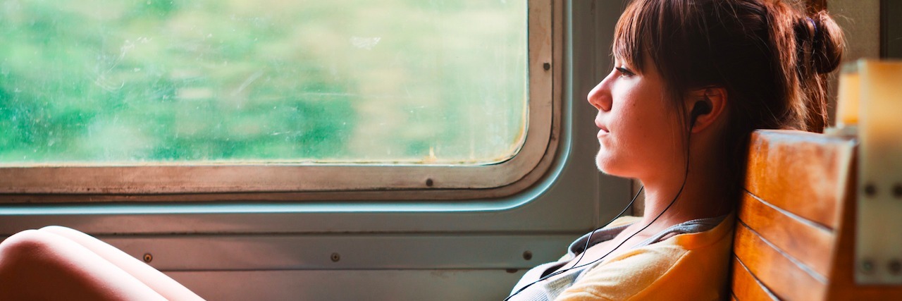 How to Figure Out What Mental Illness You Have girl sitting on a train listening to music on headphones