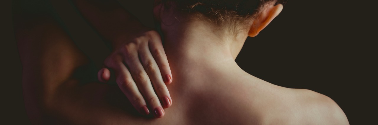 Common Symptoms of Ehlers-Danlos Syndrome woman with a neck injury on black background