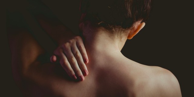 woman with a neck injury on black background