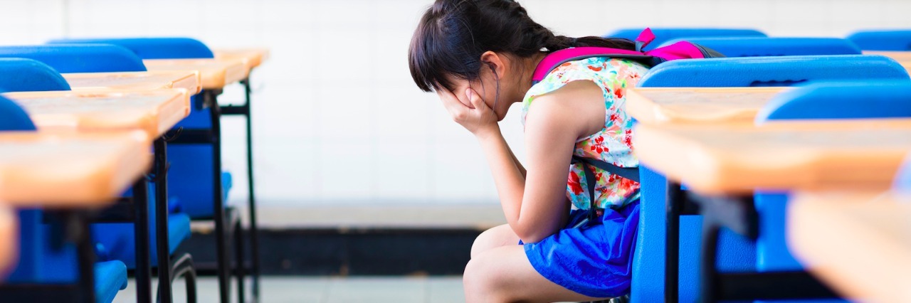 What Teachers Should Know About Anxiety in Children Student sitting at desk in classroom with head in hands