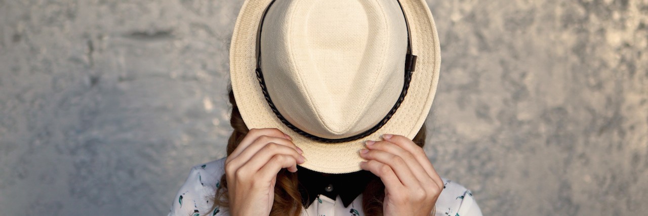 Best Advice for Dealing With Social Anxiety a woman hiding behind her hat