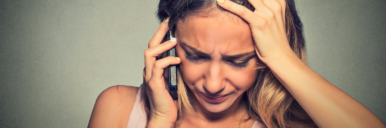 Why You Should Call a Suicide Helpline A woman looking upset on the phone