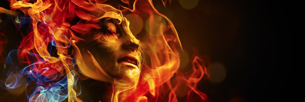 woman's face surrounded by colored flames