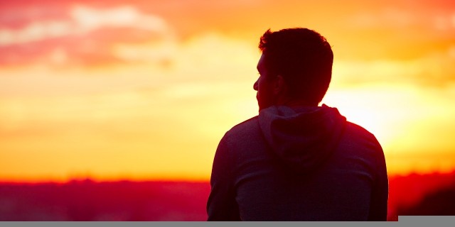 man looking at the sunrise