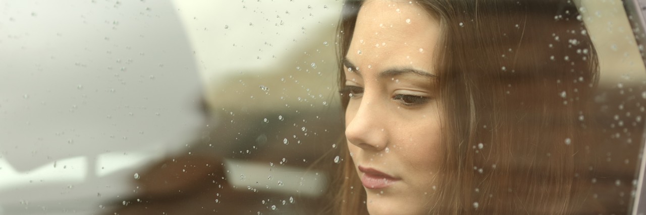 PTSD: Finding the New Me Sad woman looking down through a car window