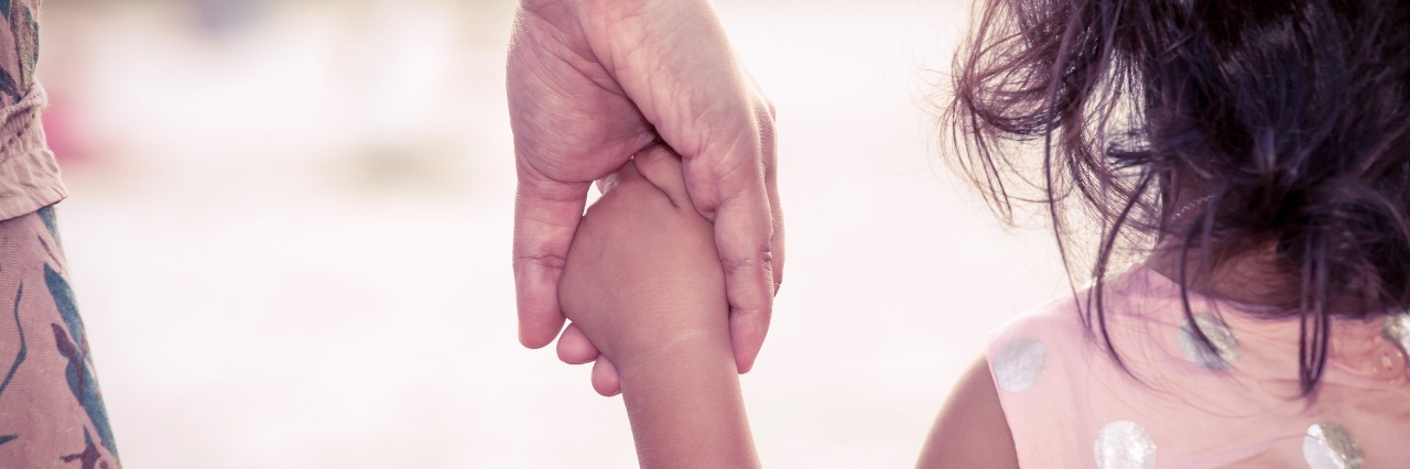 close up of mother holding daughters hand