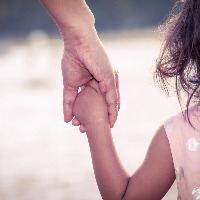close up of mother holding daughters hand