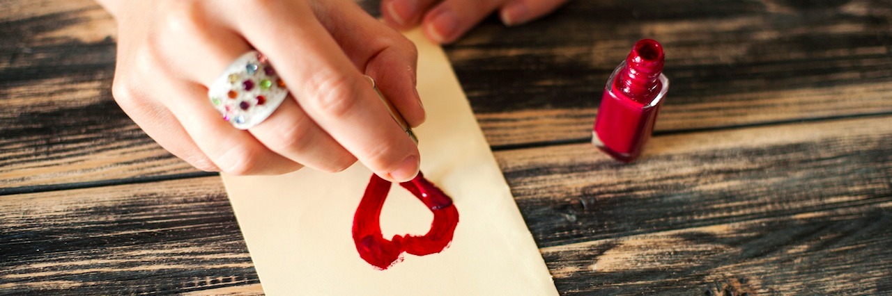 A Letter to Myself Before My Anorexia Diagnosis A woman painting a heart on a piece of paper