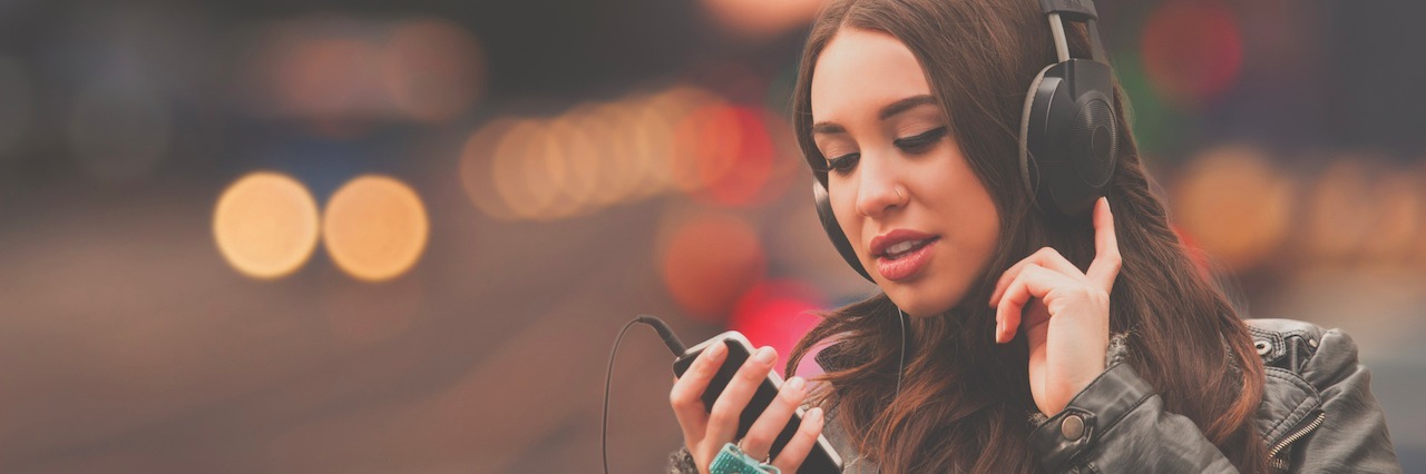 What Songs to Listen to During the Rough Days With Anxiety girl listening to music standing near a street