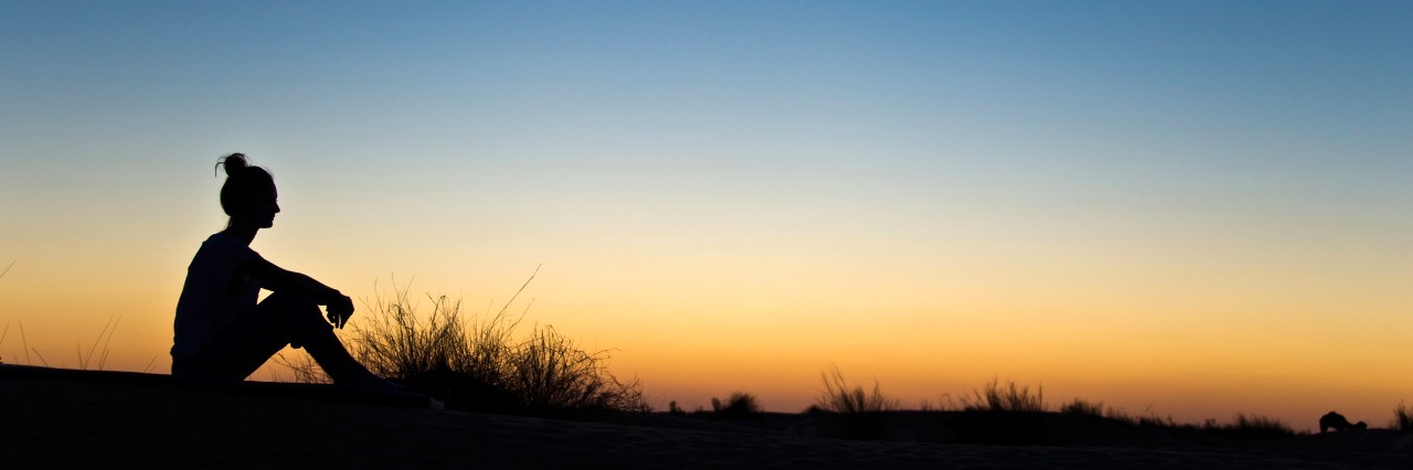 Anger and Grief After Ehlers-Danlos Syndrome Diagnosis Silhouette of a woman sitting in the sunset