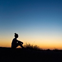 Silhouette of a woman sitting in the sunset