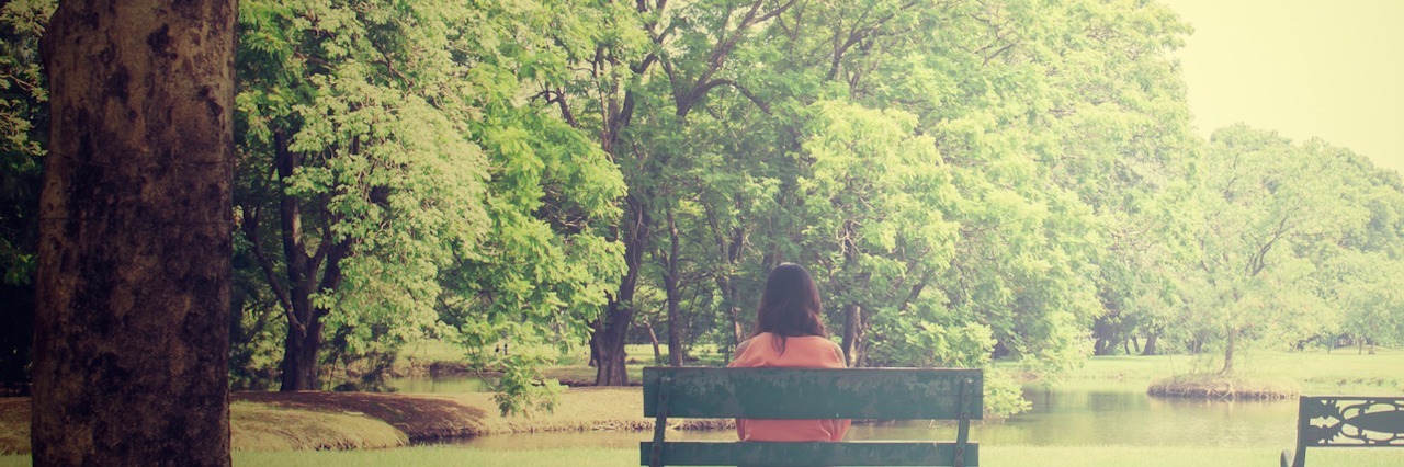 What I Wish People Knew About Life After My Miscarriage Woman sitting on bench in a park