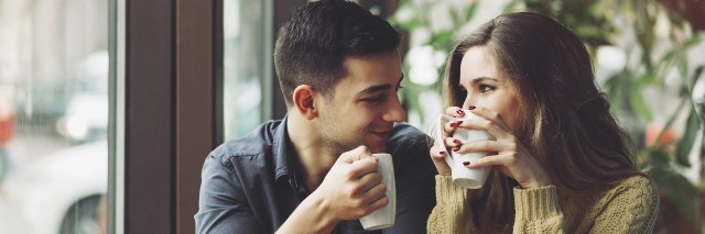 couple drinking coffee and talking in a coffee shop