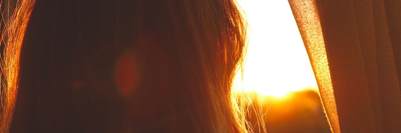 Strategies That Help Me Accept the 'Bad Days' With My Chronic Pain Woman looking out window at sunset