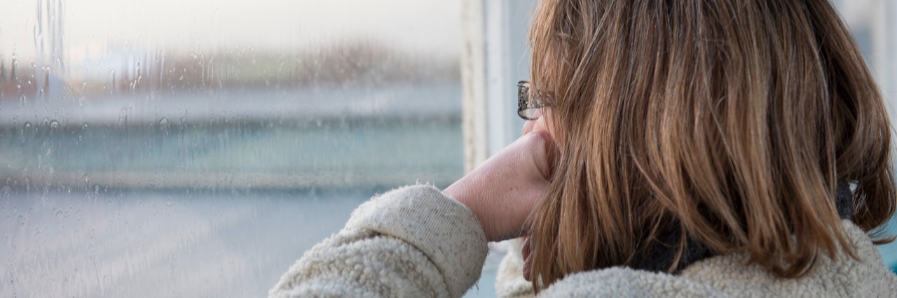Bipolar Disorder: Trapped in My Mind woman looking out the window on a rainy day