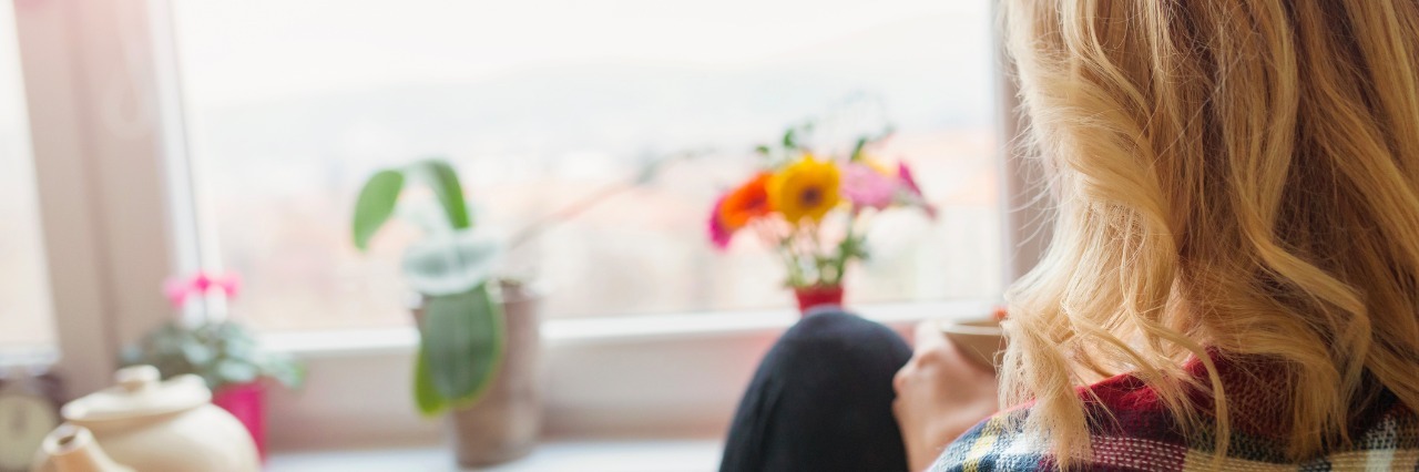 Anxiety and Depression: What a Good Day Looks Like a woman relaxing with a cup of tea in a sunny kitchen