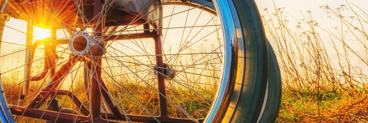 Becoming Disabled in Trump's America Wheelchair on the meadow at sunset.