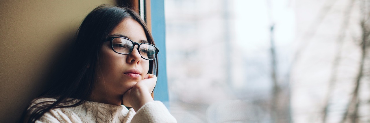 What Trichotillomania Has Taught Me sad girl looking out the window