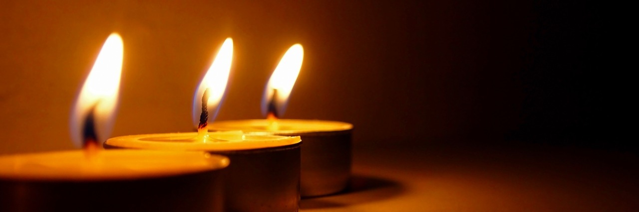 three tea light candles burning in a row