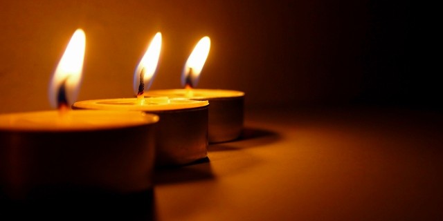 three tea light candles burning in a row
