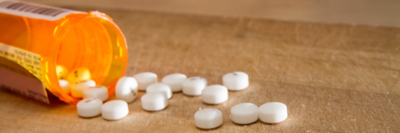 Bipolar Disorder: Coping With Side Effects of Medication drugs spilling out onto table from tipped over orange pill bottle