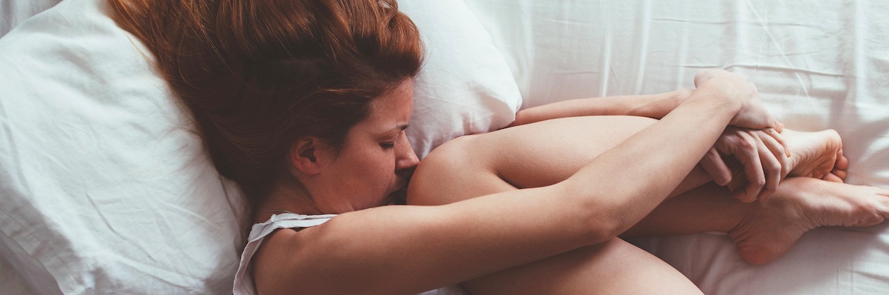 Why I Spend So Much Time in Bed With Depression young woman curled up in bed