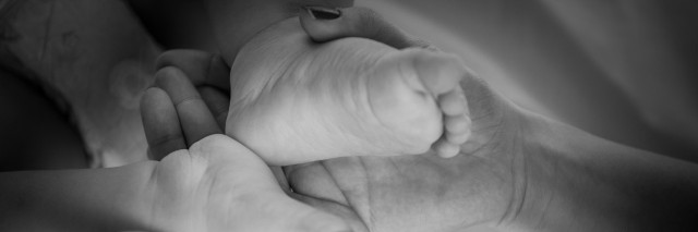 a mothers hands holding her babys feet