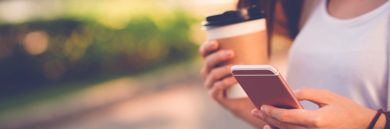 Getting Anxiety When You Get a Text Is Not Ghosting Close-up image of woman texting and drinking coffee outdoors
