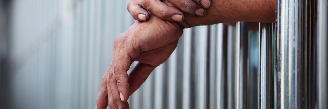 hands coming out of a prison cell