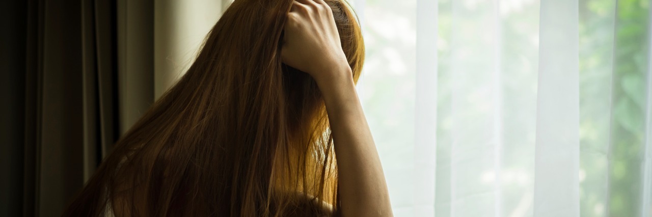 My Social Anxiety Makes Me Afraid of Other People woman with long hair looking out a window