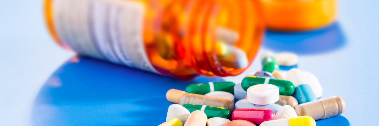 Why It's So Important to Take Medication for Bipolar Disorder medication spilling from a pill bottle