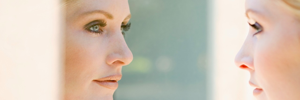 Body Image: Affirmations for When It's Hard to Look in the Mirror woman looking at her reflection in the mirror