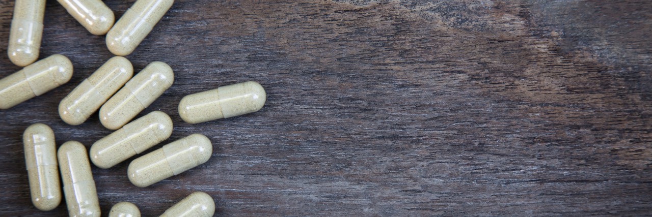 many capsule pill on wooden background