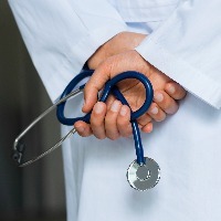Close up of hands of doctor holding stethoscope in a hospital