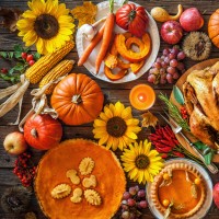 Thanksgiving dinner. Roasted turkey with pumpkins and sunflowers on wooden table