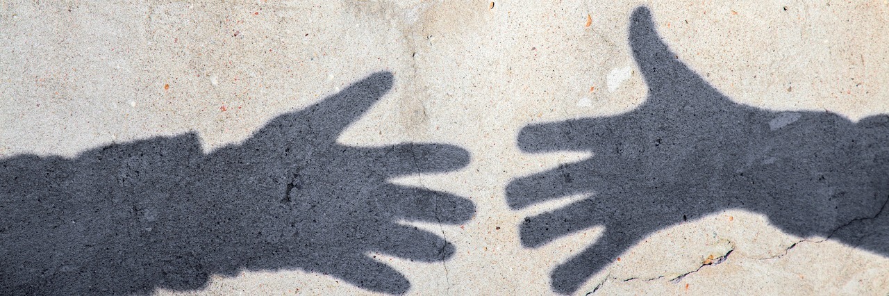 two shadow hands reaching for each other