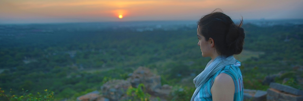 Girl Looking at Sunset Over Ruins and Field India