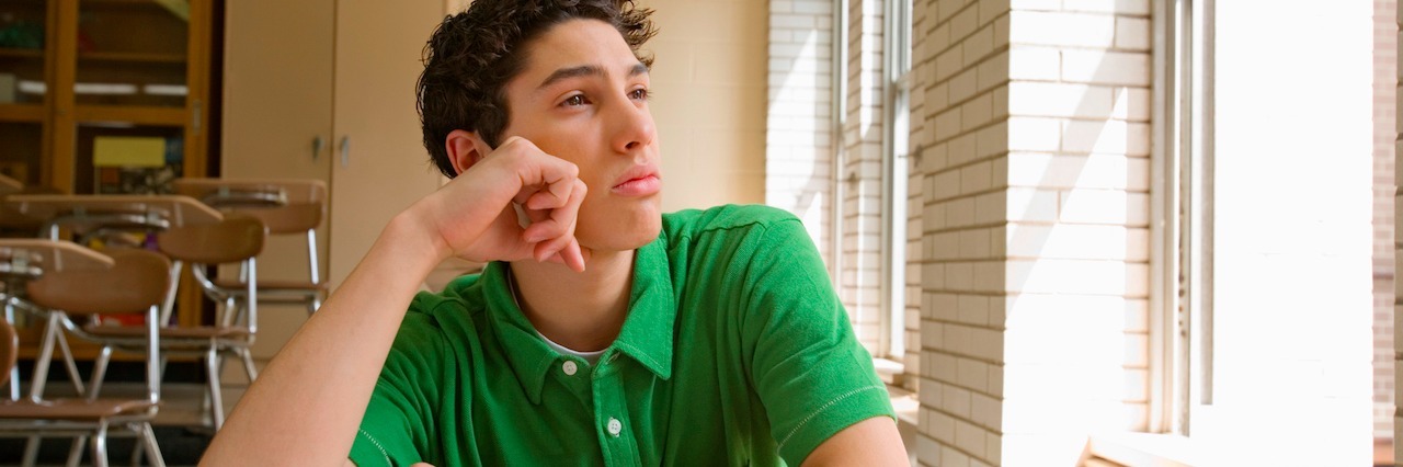 Teenage boy daydreaming in classroom