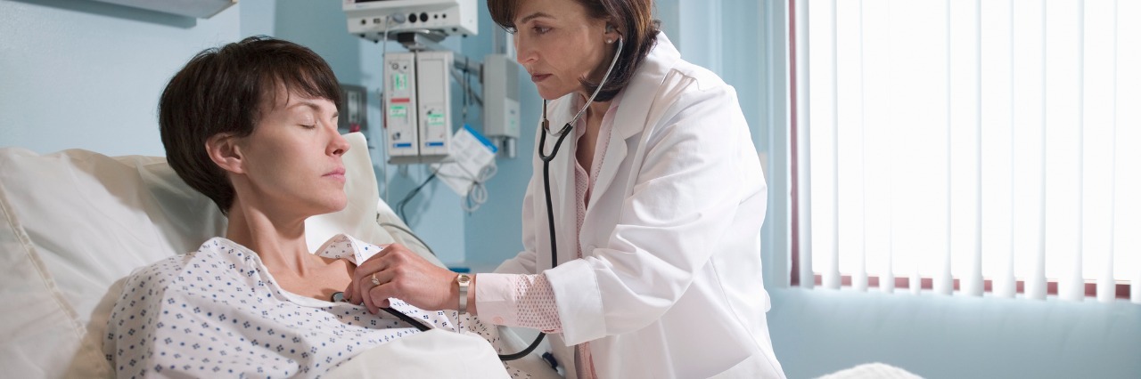 Opening Up and Feeling Vulnerable at Doctor Appointments female patient in a hospital gown is examined by a doctor