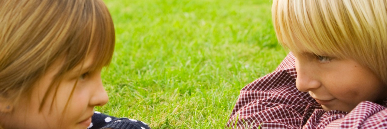 What a Child With Autism Acts Like on the Outside vs. the Inside Boy and girl lying down in grass