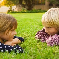 Boy and girl lying down in grass