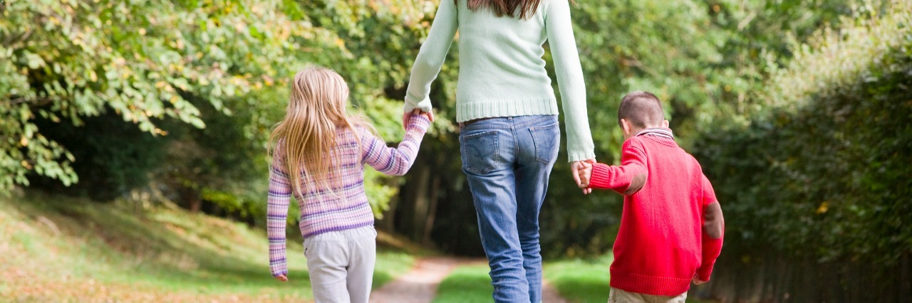 The People I'm Thankful for as a Special Needs Parent mother and two children walking on woodland path in autumn