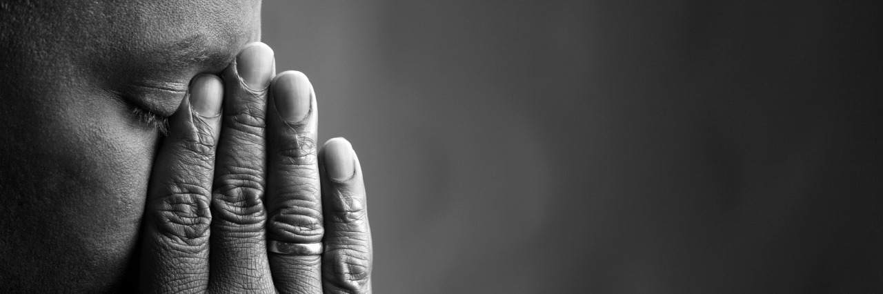 black and white photo of man holding his fingers over his nose