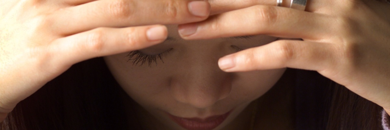 My Frustration Over Media Portraying Misophonia as 'Sound Rage' Woman with head down and eyes looking down, hands on forehead