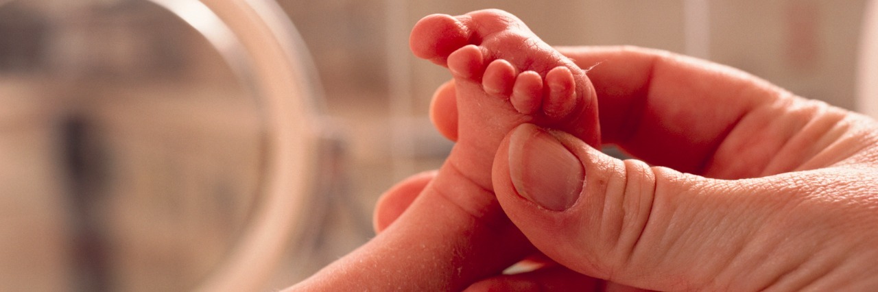 A Letter to NICU Parents From a Nurse Parent holding baby's foot in hospital