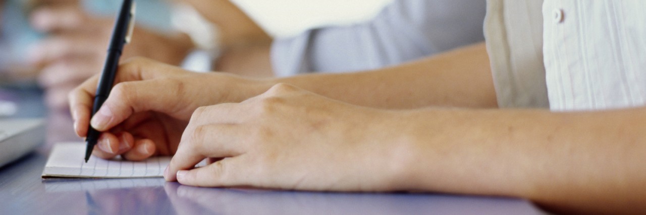 Tips for Parents Preparing for Their Child's Next IEP Meeting Person taking notes in meeting