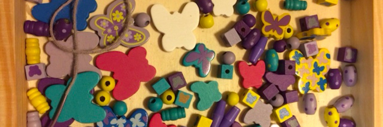 an array of differently colored and shaped beads in a tray