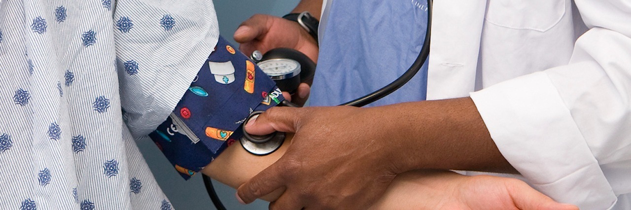 Living With Symptoms and No Diagnosis Doctor taking a patient's blood pressure