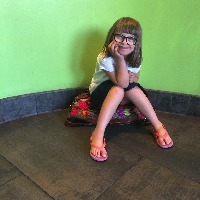 young girl sitting in the corner of a green room