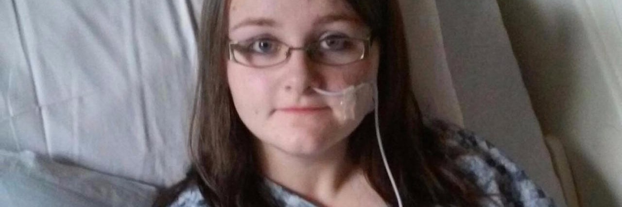 Getting Through Hard Parts of Ulcerative Colitis hannah wearing a hospital gown and laying in a hospital bed